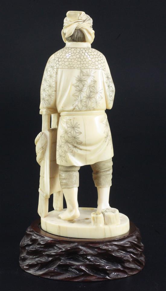 A Japanese ivory figure of a farmer holding his pipe, signed Gyozan, early 20th century, 17.5cm excl. wood stand